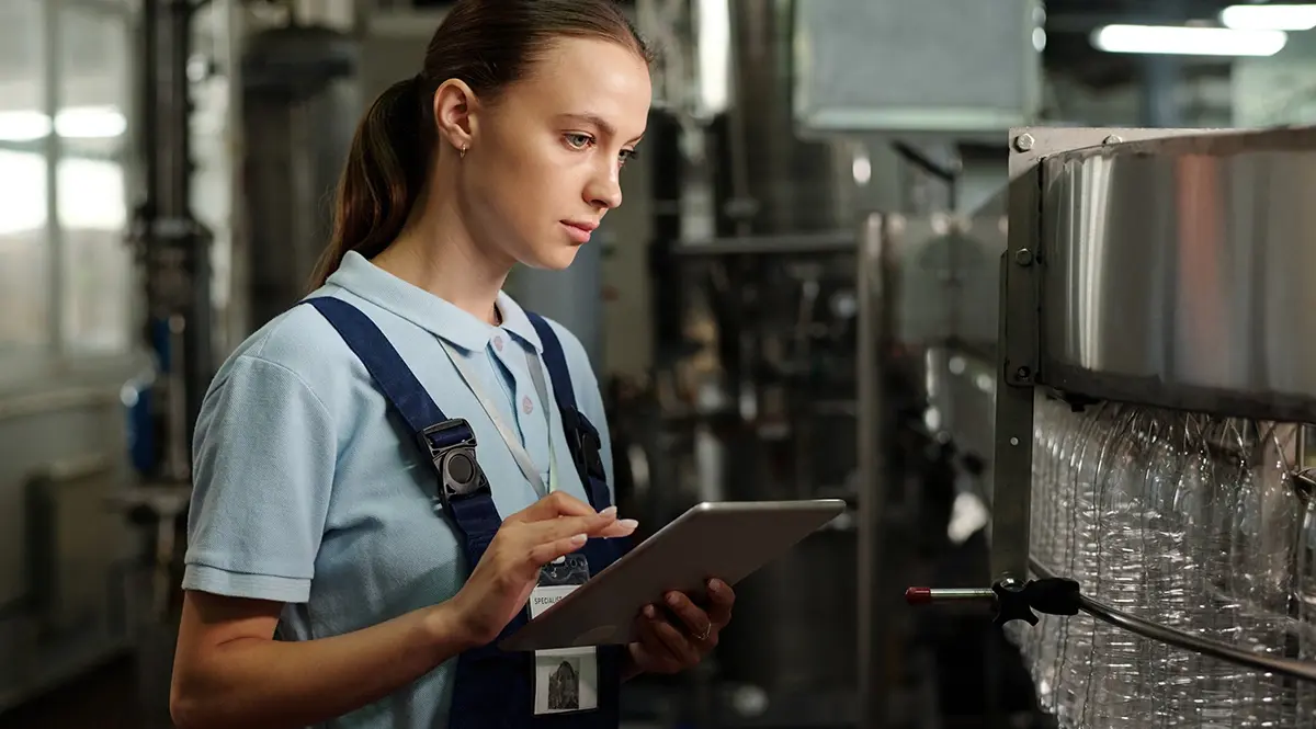 Woman using tablet to monitor quality control in manufacturing