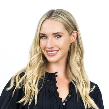 Gemma Davidson, a blonde woman with blue eyes, smiles in a studio portrait.