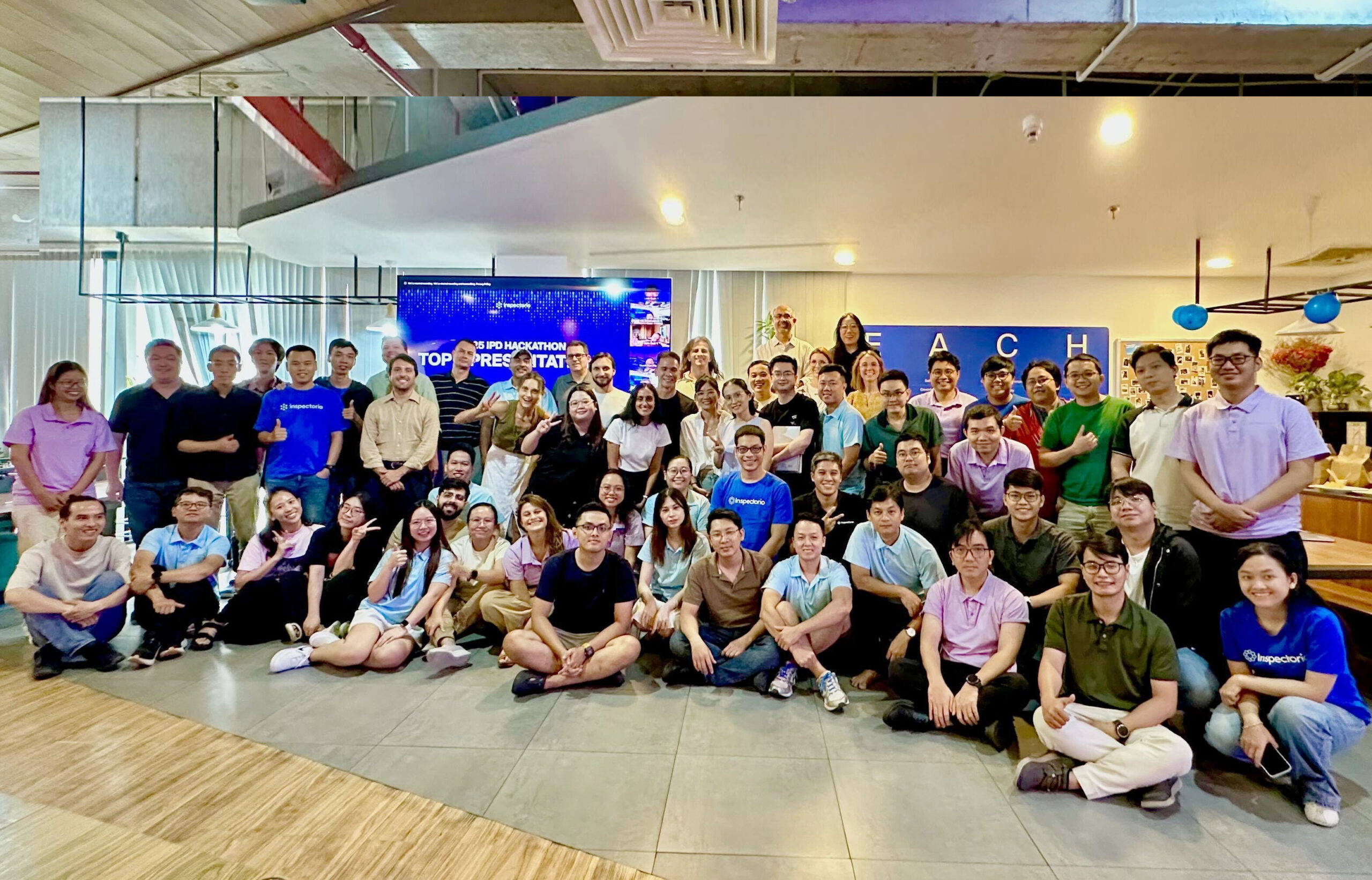 Group photo of IPO Hackathon participants at a tech company event.
